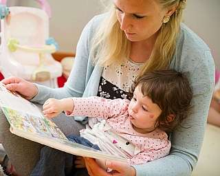 Eine Frau liest einem Kind ein Buch vor