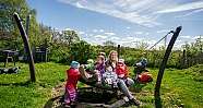 Eine Erzieherin mit Kindern auf einer Nestschaukel